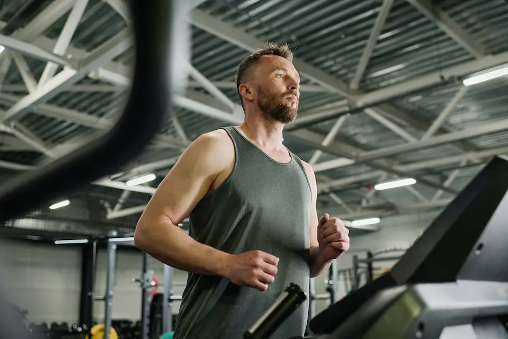 hombre corriendo en una cinta ejercicios para reducir ginecomastia